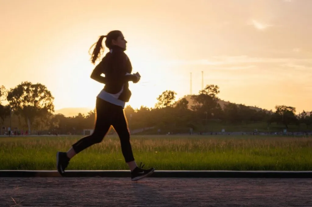 Mujer corriendo al atardecer cuidando su salud con omega-3